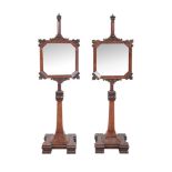 A pair of mahogany mirrors on stands , circa 1870 and later, each with mirror fixed to the stem
