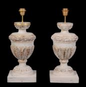 A pair of carved, painted and parcel giltwood urns fitted as table lamps, 20th century, with