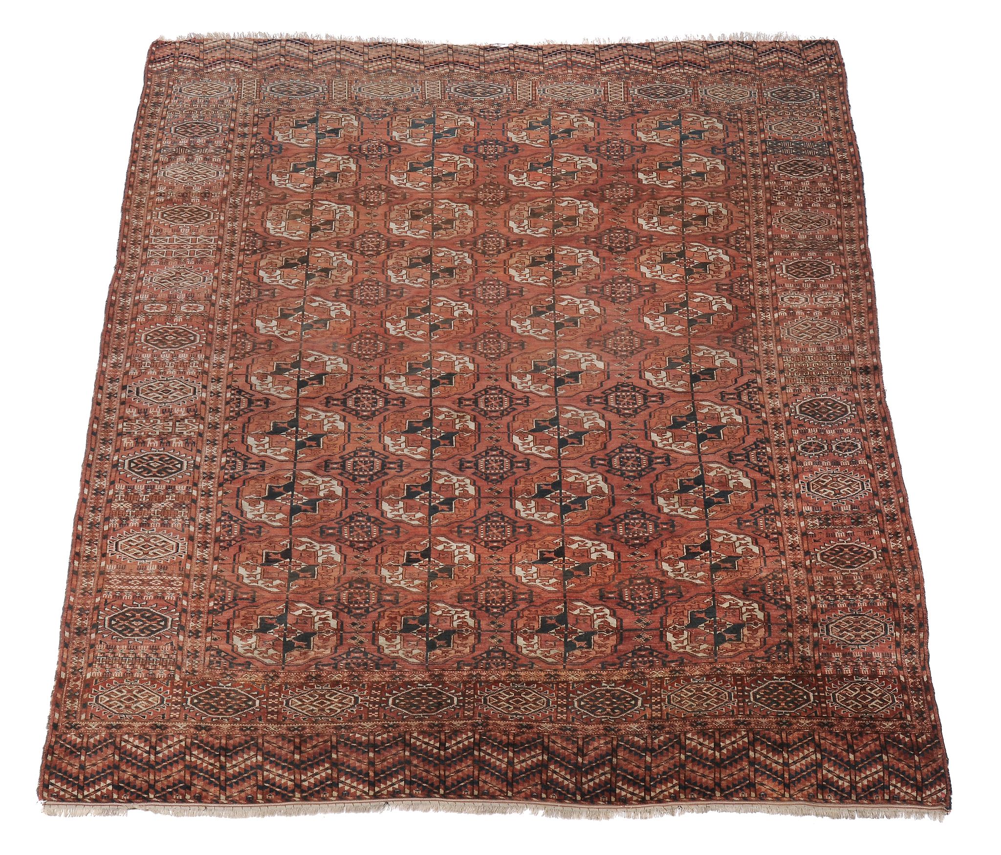 A Bokhara carpet, the madder field decorated with rows of geometric motifs and within multiple