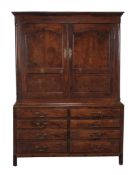 A George III oak press cupboard, circa 1780, the base with six false drawer fronts and two drawers