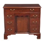 A George III mahogany kneehole desk, late 18th century, the long secretaire drawer enclosing a