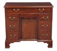 A George III mahogany kneehole desk, late 18th century, the long secretaire drawer enclosing a