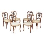 A set of six Victorian walnut dining chairs , circa 1870, each with decorative vertical splat