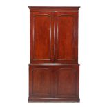 A Victorian mahogany cabinet, circa 1860, the panel doors enclosing fitted interior with