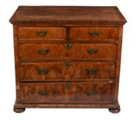 A George II walnut chest of drawers, circa 1740, with two short and three long drawers, on turned