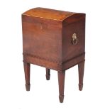 Ω A mahogany dome top cellerette , early 19th century, the rosewood banded lid opening to a divided