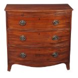 A George III mahogany chest of drawers , circa 1810, of bowfront outline, with brushing slide above