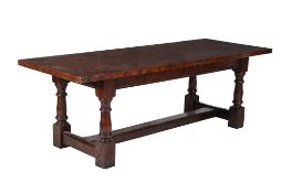 An oak refectory table in Charles II style , the plank top above square section and turned legs