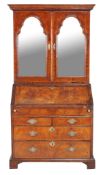 A walnut bureau bookcase , circa 1715 and later, the mirrored doors enclosing adjustable shelves,