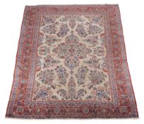 A Kashan carpet, the cream field profusely decorated with sprigs of flowers in tones of blue and