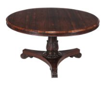 Ω A William IV rosewood circular centre table , circa 1835, the lappet carved stem above a concave