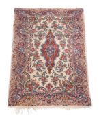 A Qum rug, the cream field profusely decorated with sprigs of flowers in tones of blue, pink and