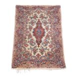 A Qum rug, the cream field profusely decorated with sprigs of flowers in tones of blue, pink and