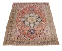 A Heriz carpet, the madder field with central navy and cream medallion, cornered by spandrels,