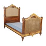 A French walnut and parcel gilt bed, early 20th century, in the early 19th century taste,