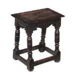 An oak joint stool in Charles I style , the solid seat above turned legs and peripheral stretchers