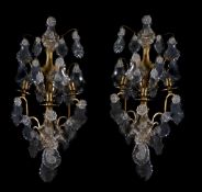 A pair of brass and cut glass hung three light wall appliques, early 20th century, the sconces