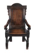 A Charles II panel back armchair, circa 1660, the arched panel back, above downswept arms and a