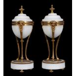 A pair of French white marble and gilt bronze mounted urns, circa 1870, each with toupie finial,