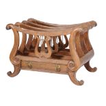 Ω A George IV rosewood Canterbury, circa 1825, with swept top above scroll supports and central