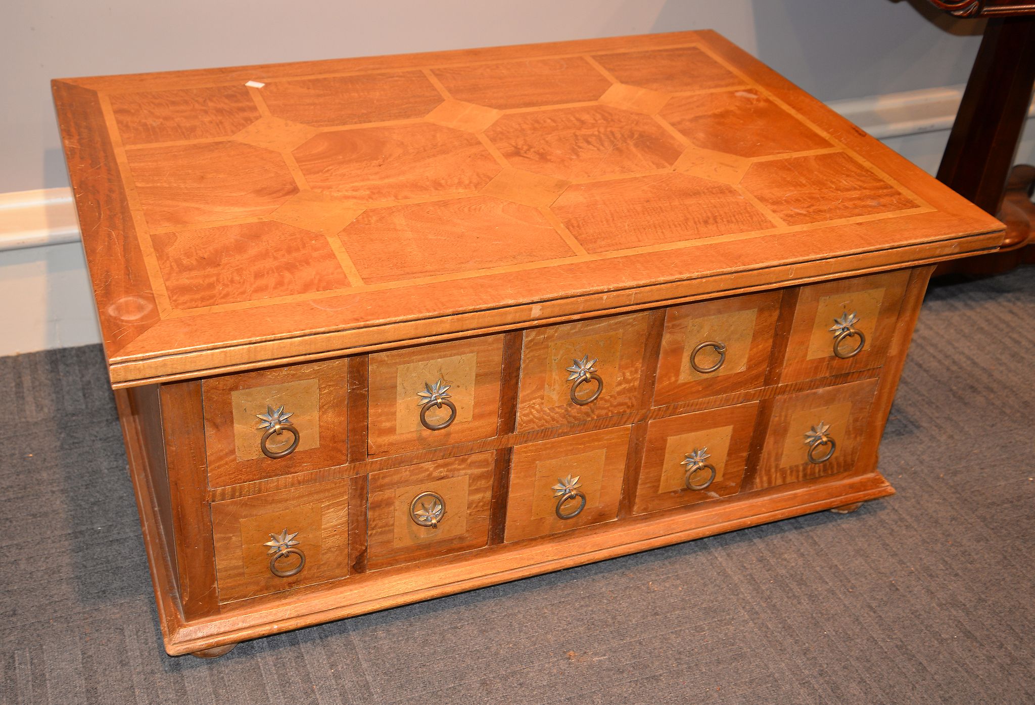 A modern mixed wood parquetry coffee table, the base with an arrangement of drawers to each opposing