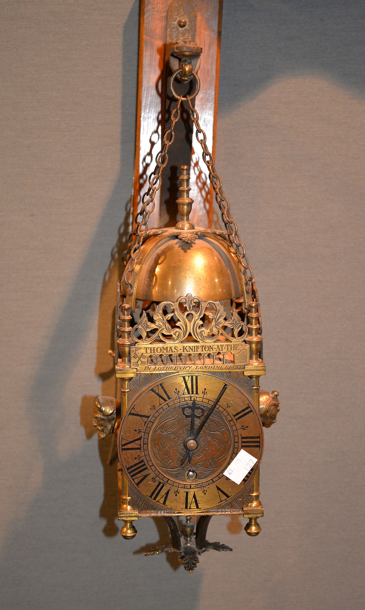 A modern reproduction of a 17th century brass lantern timepiece, the case with applied maskheads,