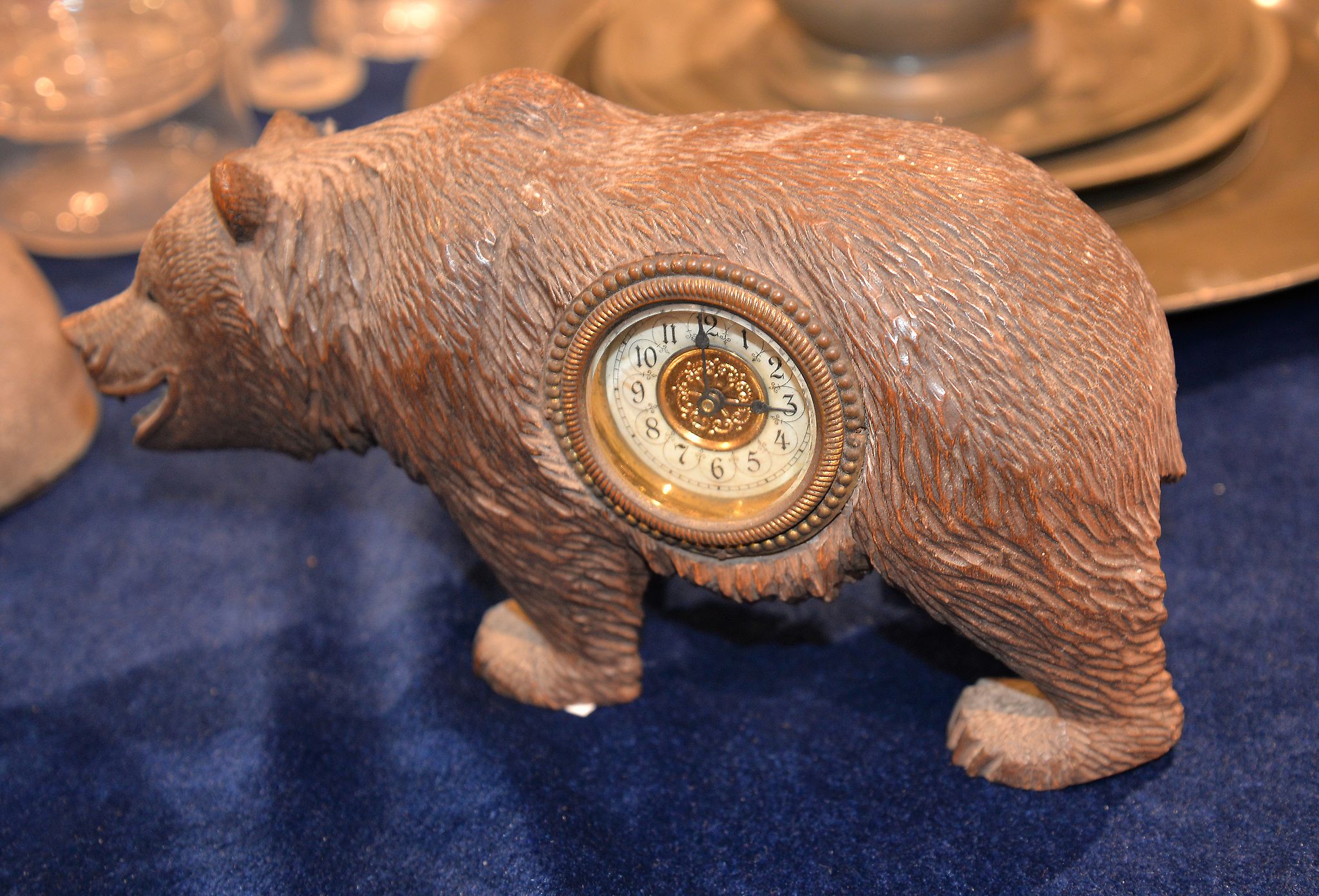 A Black Forest carved wood bear, with inset timepiece movement, 23cm long