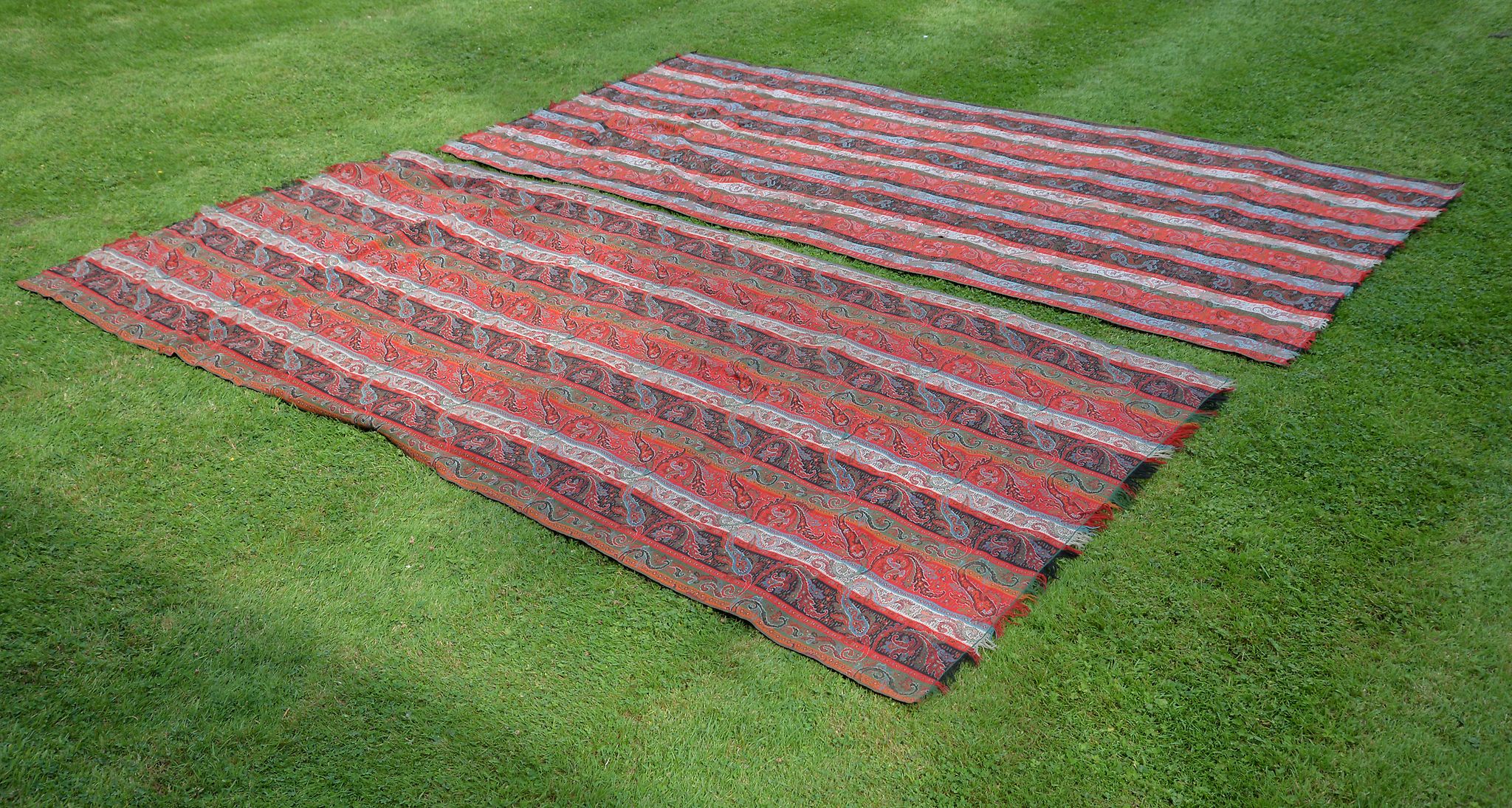 Two similar Paisley pattern throws, each approx. 305cm x 150cm, together with a small tapestry