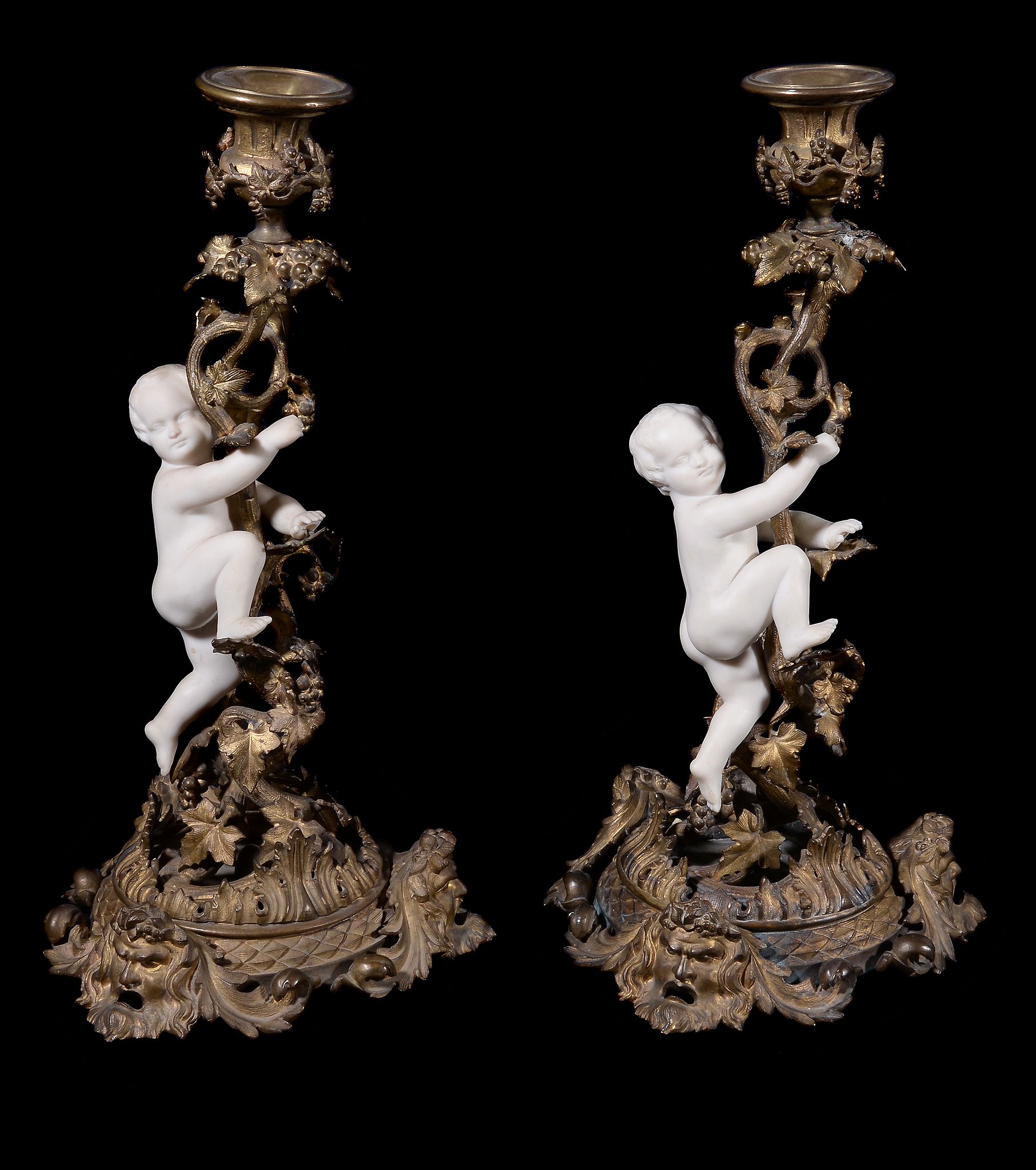 A pair of Continental gilt metal and biscuit porcelain candlesticks, third quarter 19th century,