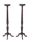 A pair of Edwardian mahogany circular torchère stands, circa 1910, one incorporating an earlier