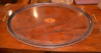 An Edwardian mahogany oval tray, with brass handles and central marquetry medallion, 71cm long