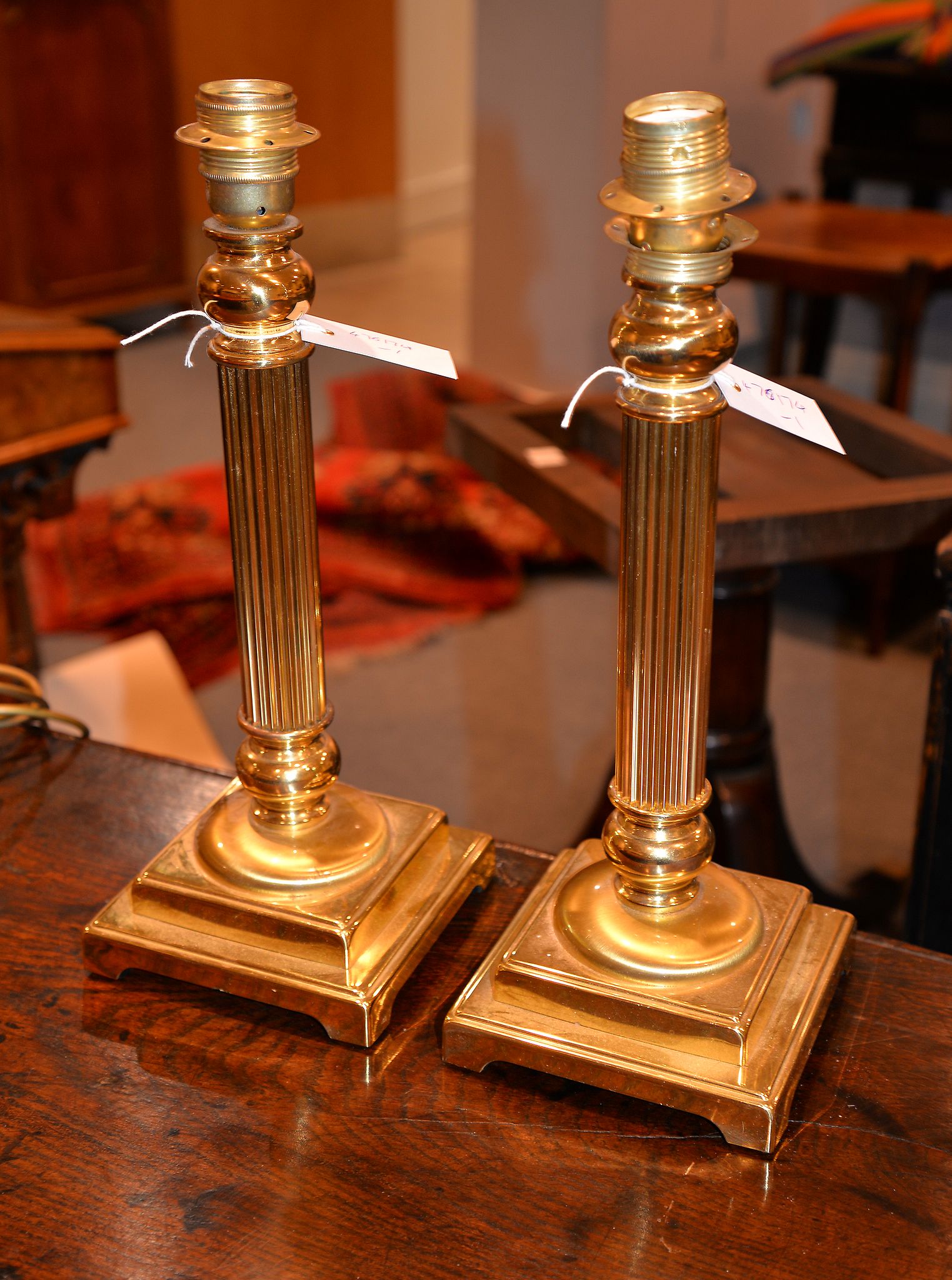 A pair of brass columnar table lamps, from Mappin & Webb, each 42cm high