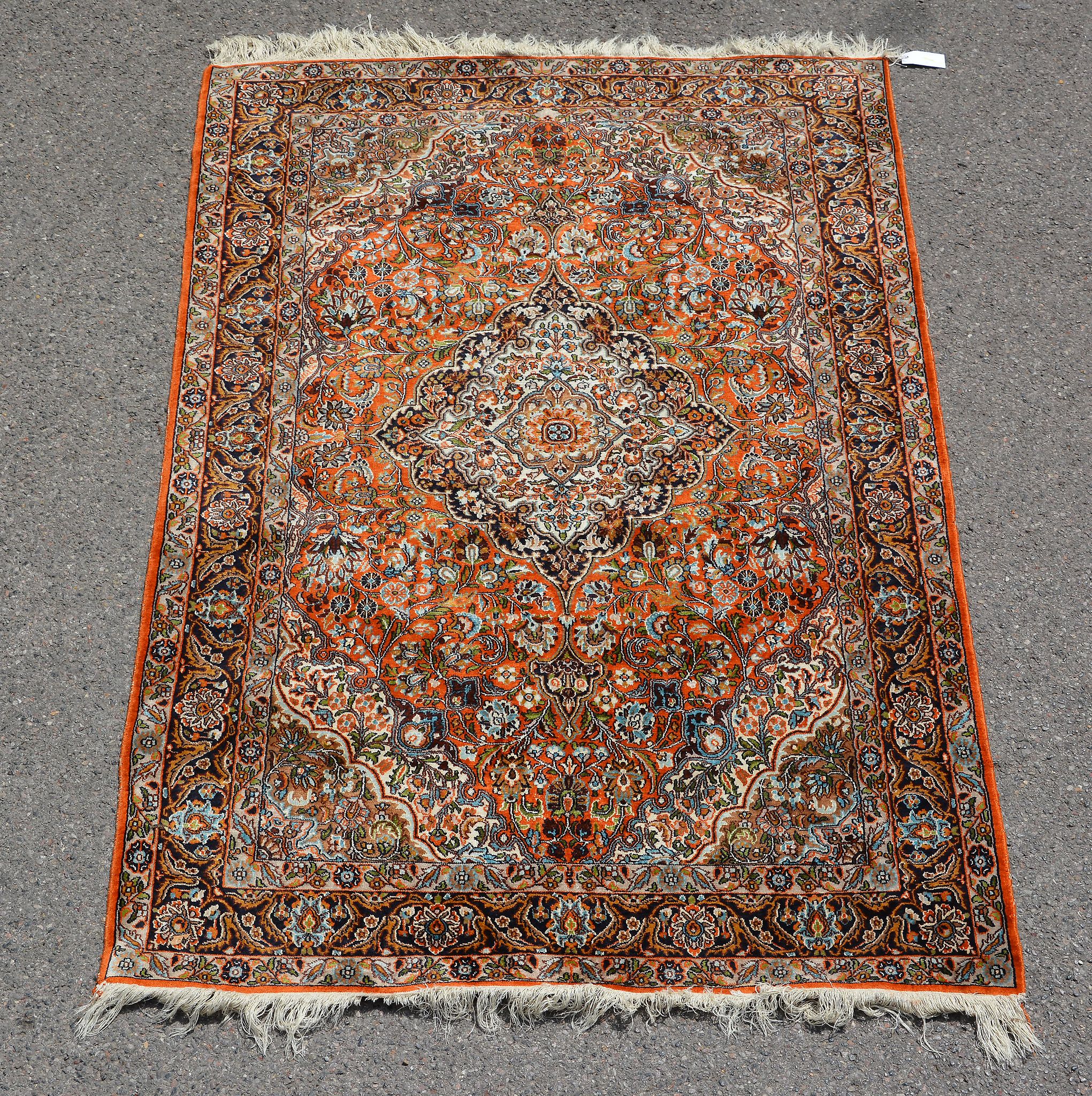 A Kashan rug, 20th century, the madder field decorated profusely with floral foliage and centred