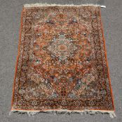A Kashan rug, 20th century, the madder field decorated profusely with floral foliage and centred