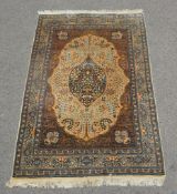 Two rugs, of Kashan design, each cream field decorated profusely with floral foliage,