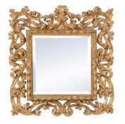 A Continental carved giltwood wall mirror in Italianate taste, the later bevelled mirror plate