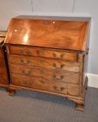 A George III mahogany bureau, the sloping flap enclosing an arrangement of drawers and pigeonholes