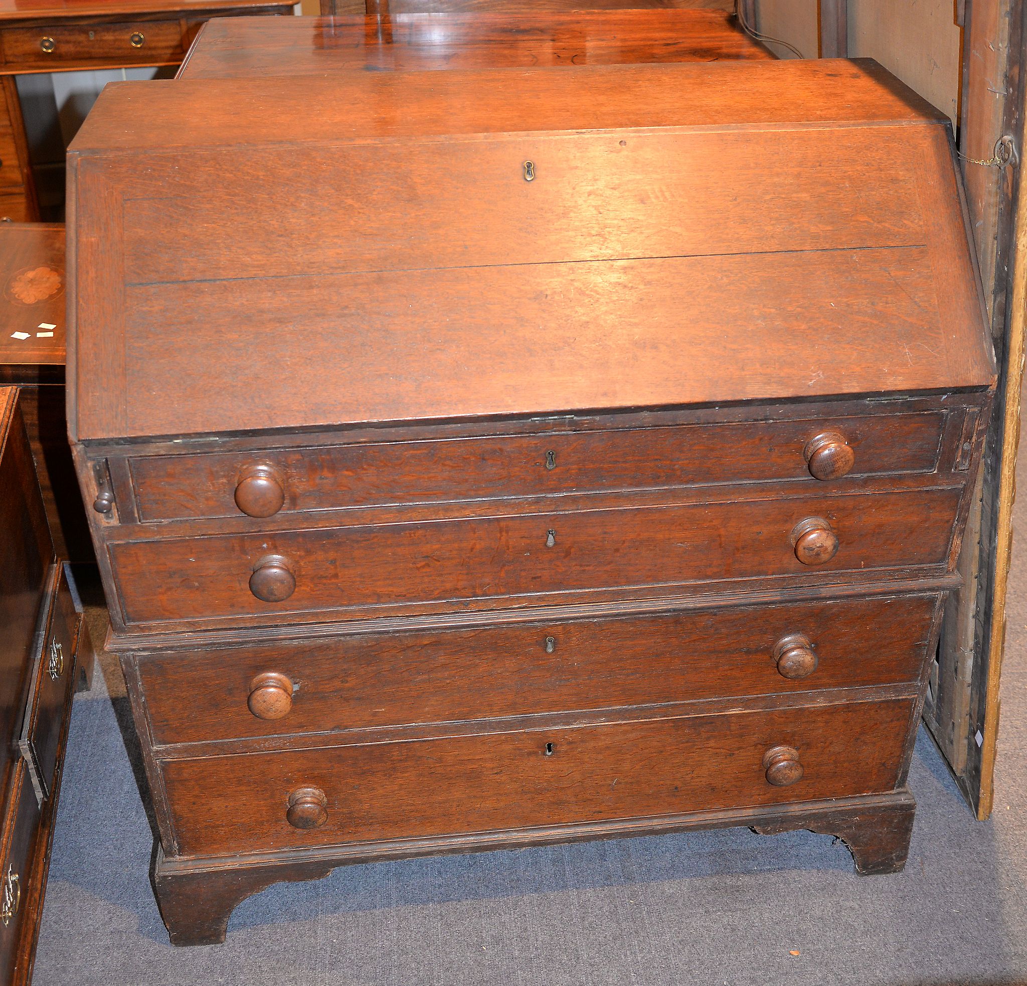 A 19th century oak bureau, with fittings enclosed by a fall, above four long drawers