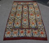 A Victorian needlepoint rug, the navy field decorated with repeated cartouche medallions decorated