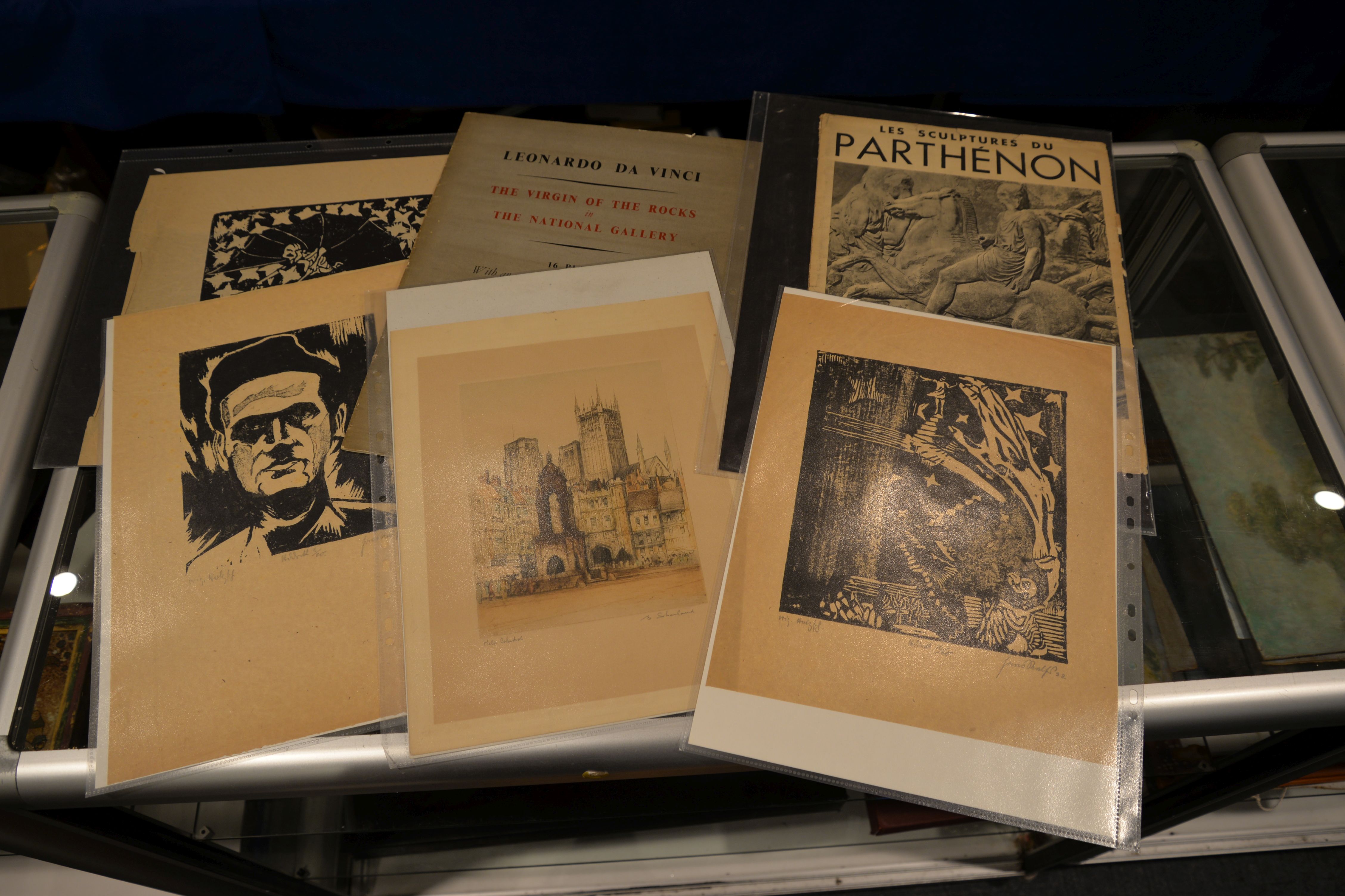 Five woodblock prints, an etching of a church, Les Sculptures Du Parthenon print, and a Da Vinci