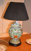 A pair of Chinese Famille Verte vases and covers, brightly painted with flowers, the vases 36cm high