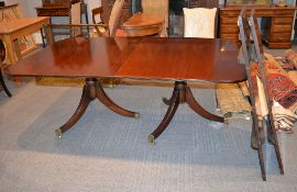 A modern mahogany twin pedestal dining table in Regency style, with two additional leaf
