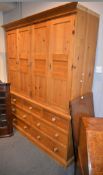 A pine cupboard, with four doors above drawers, 207cm high, 166cm wide