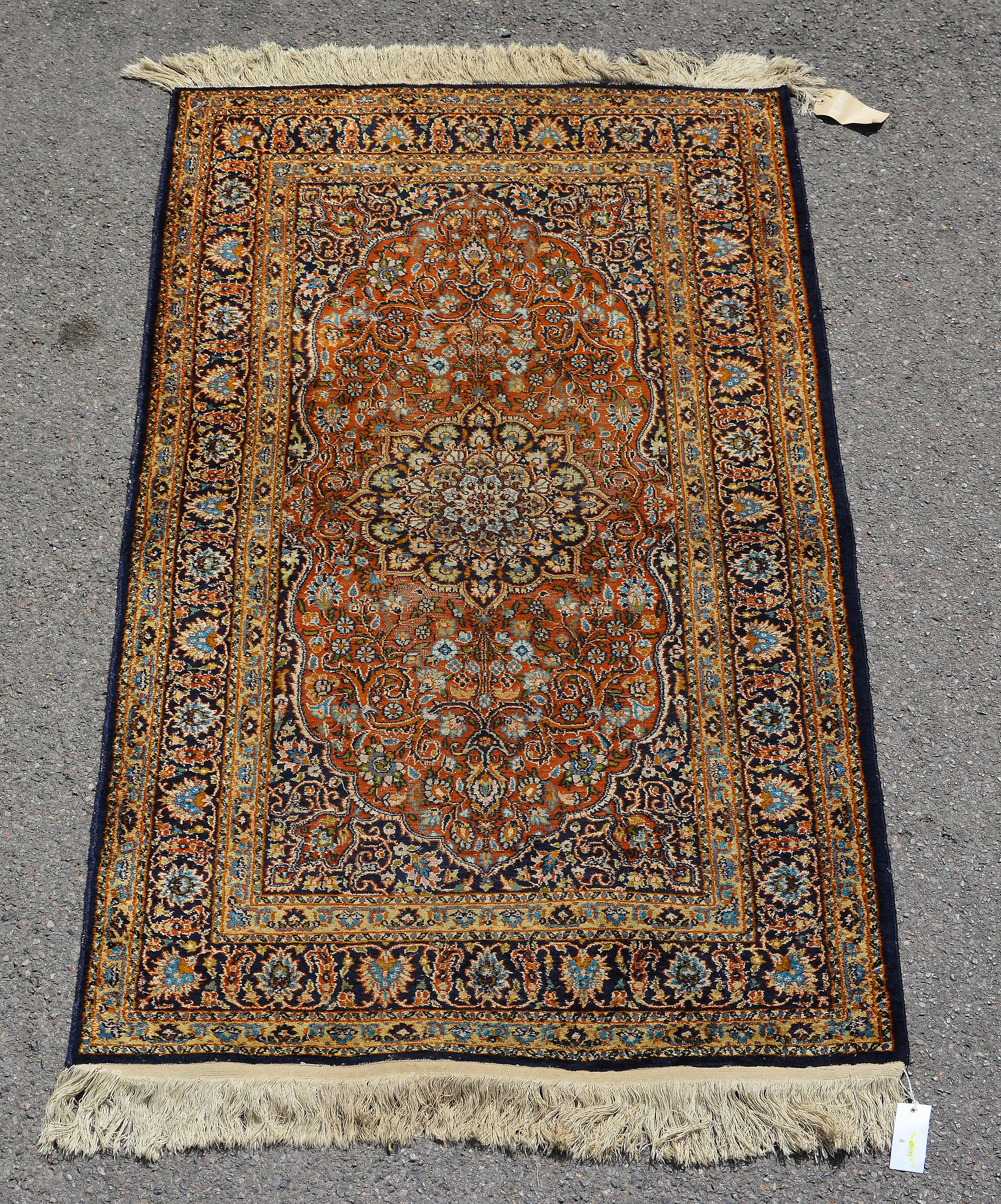 A woven carpet, of Kashan design, the pale field decorated with floral foliage and centred by a navy - Image 2 of 2