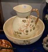 A Staffordshire pottery wash basin and ewer, moulded in relief with flowering prunus