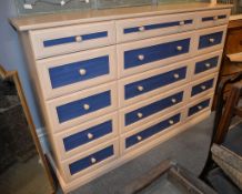 A modern vinyl veneered chest of drawers, to simulate lightwood, with blue reserves to each