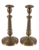 A pair of gilt metal candlesticks in Empire style, later 19th century, the urn sockets, knopped