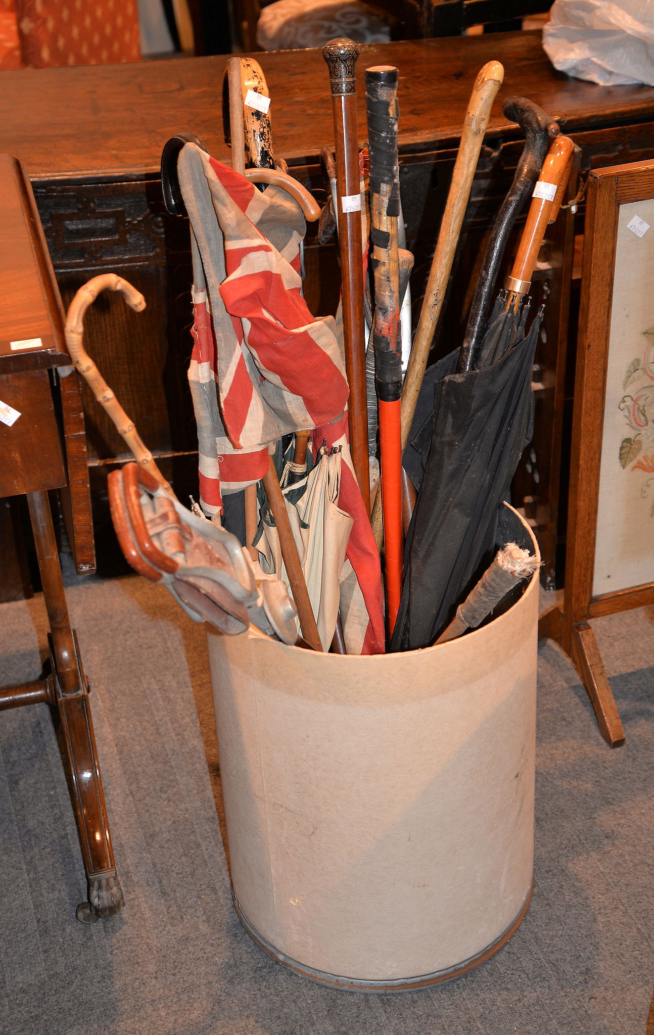 A collection of various walking sticks and umbrellas to include a Malacca example, with nielowork