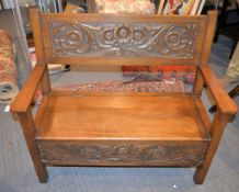 An oak settle in George III style, first quarter 20th century, with foliate carved back and