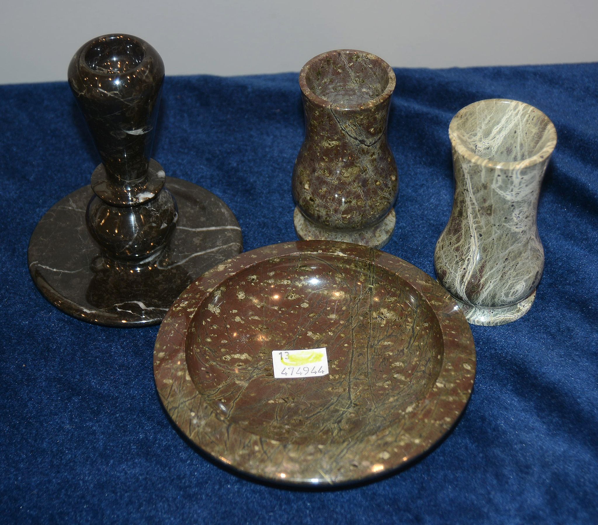 Four serpentine marble items including a taperstick, a dish, and two baluster vases